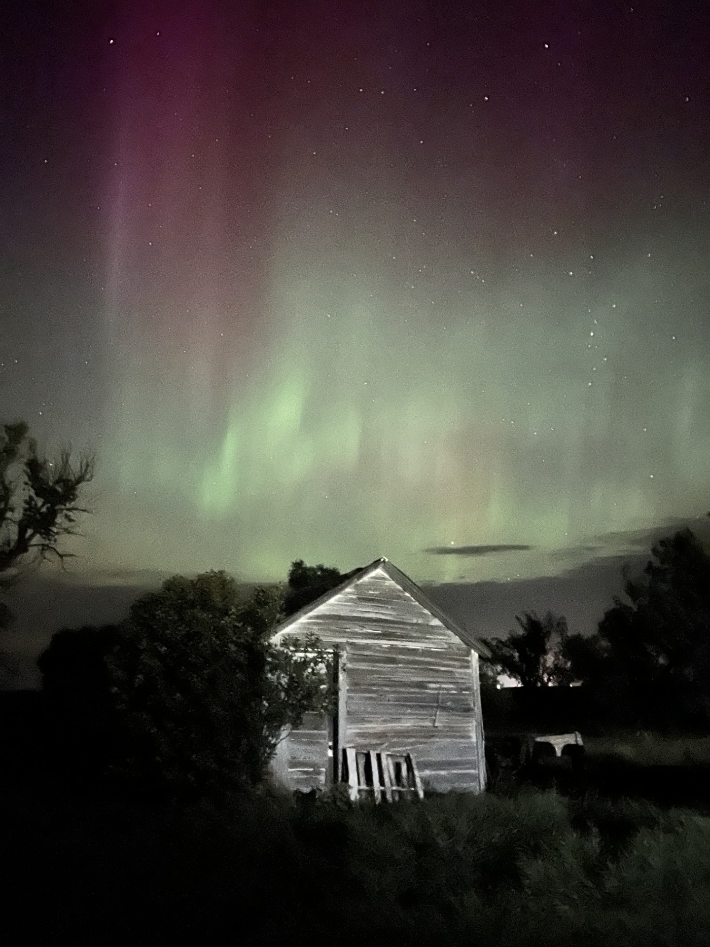 northern lights with an old building in the front